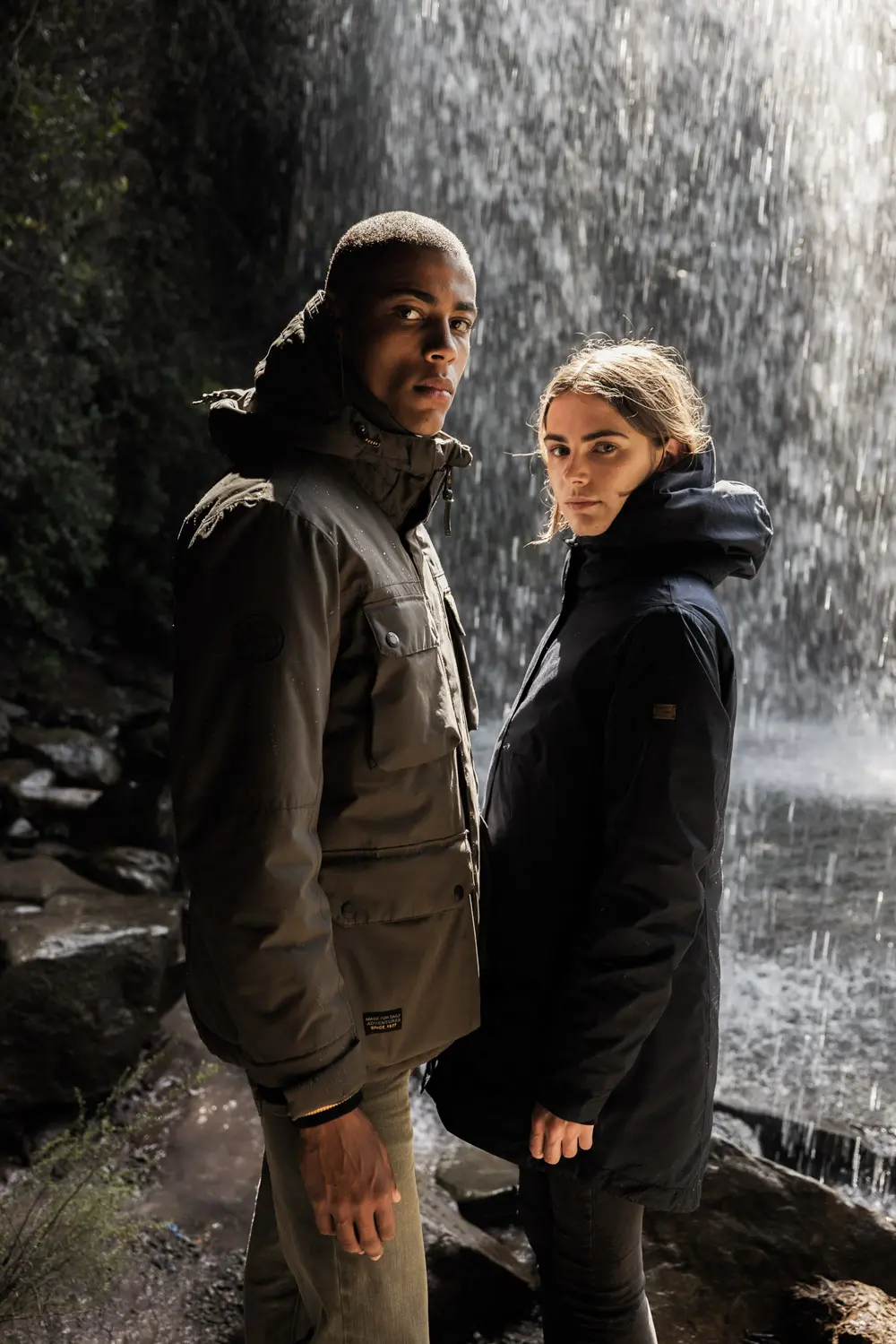 camel active - Funktionsjacke teXXXactive - Mann und Frau in teXXXactive Funktionsjacken vor Wasserfall