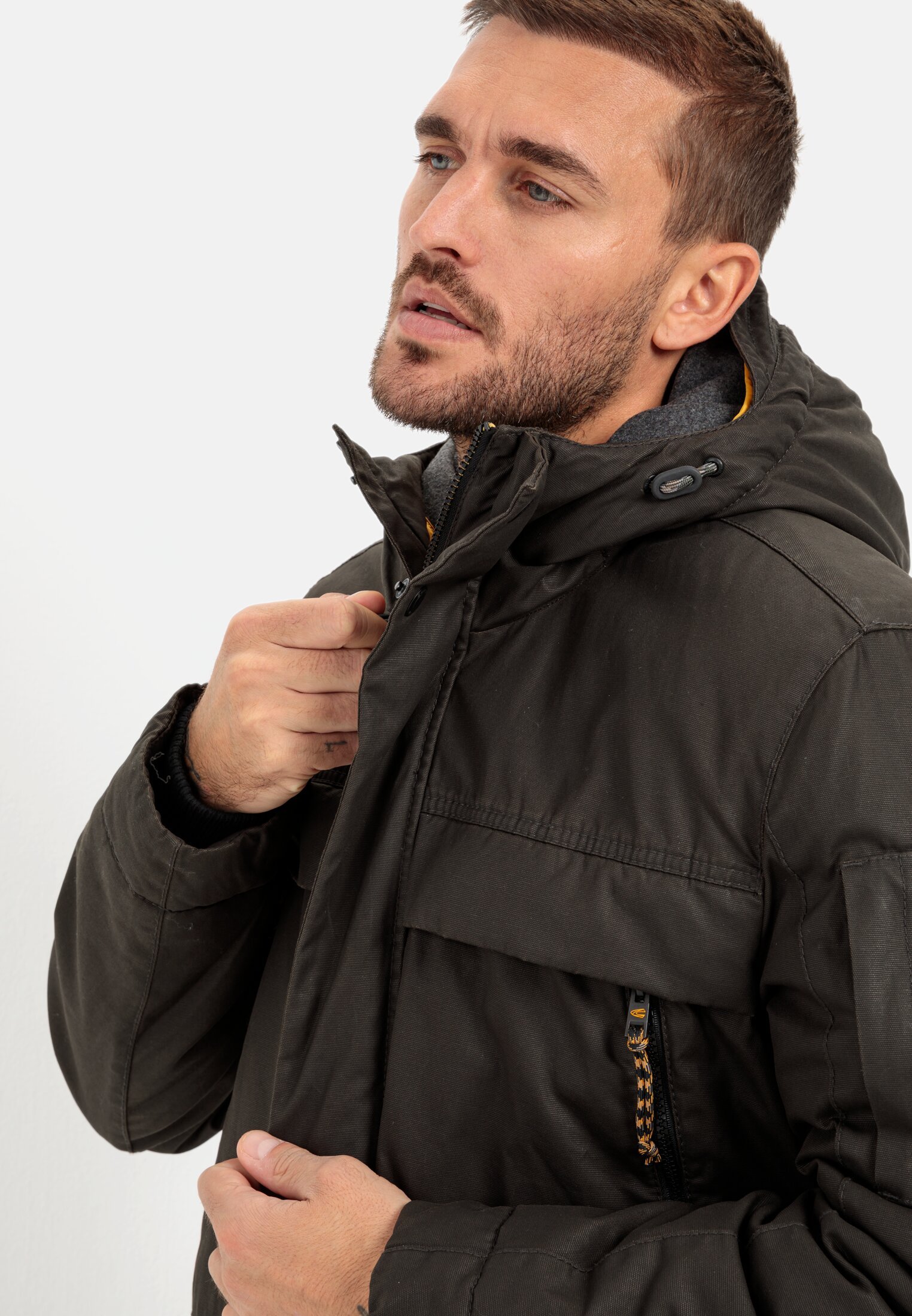 Herren Jacke aus gewachstem Canvas mit Kapuze Braun getragen detailliert nah