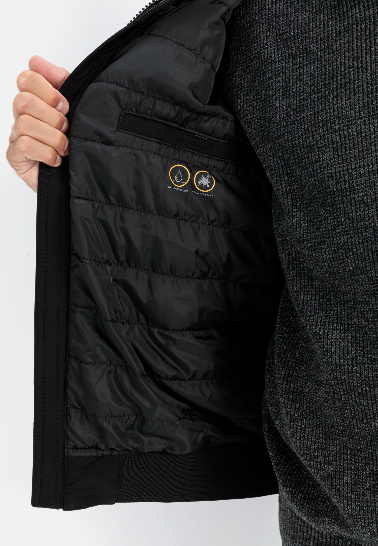 Herren Softshell Blouson mit einrollbarer Kapuze Schwarz getragen detailliert nah