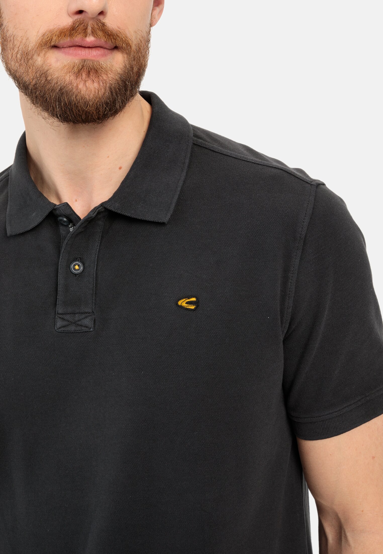 Herren Piqué Poloshirt aus zertifiziertem Organic Cotton Schwarz getragen detailliert nah
